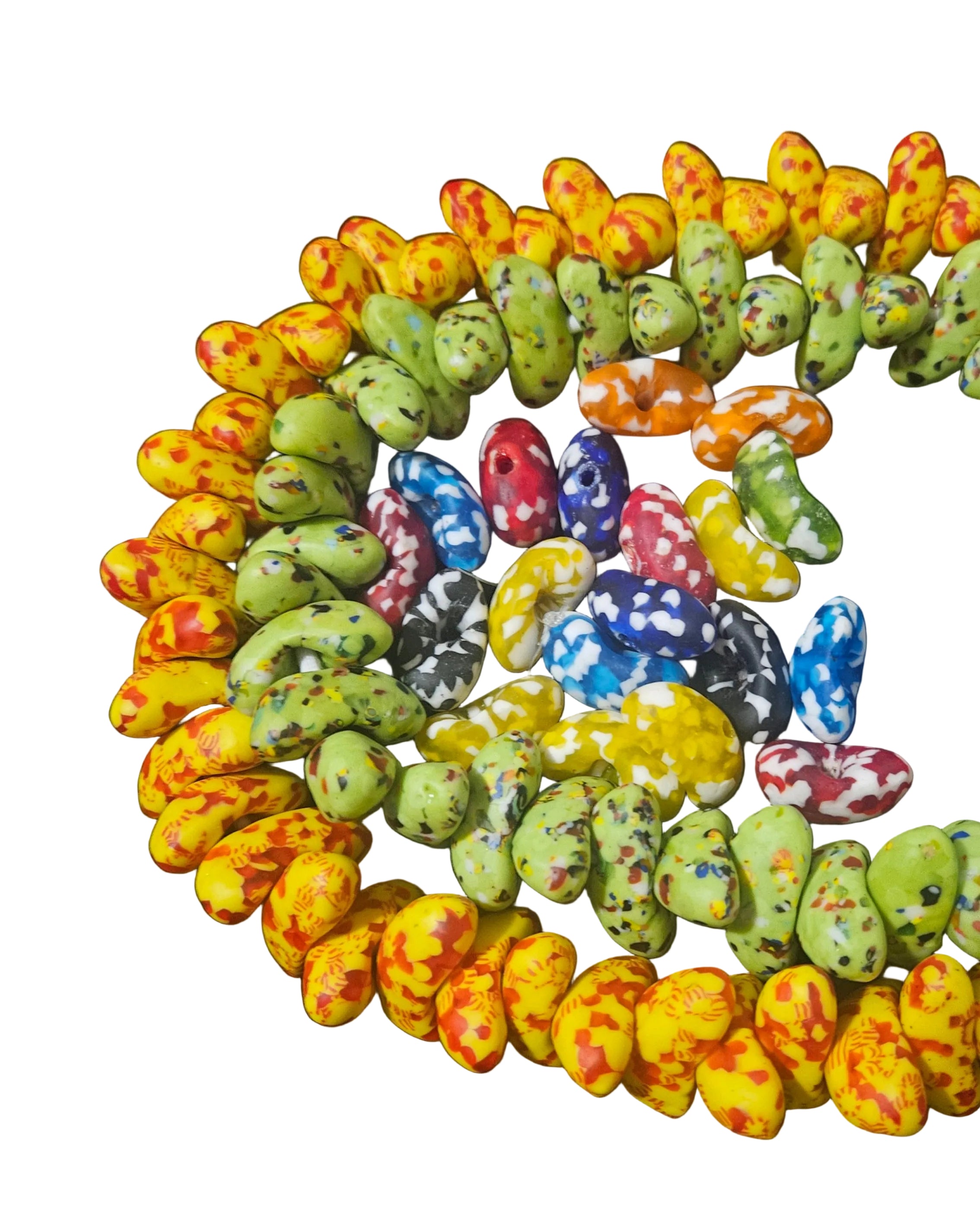 Canoe-shaped handcrafted Krobo glass beads from Ghana arranged on an ivory background, showcasing organic form and cultural craftsmanship.