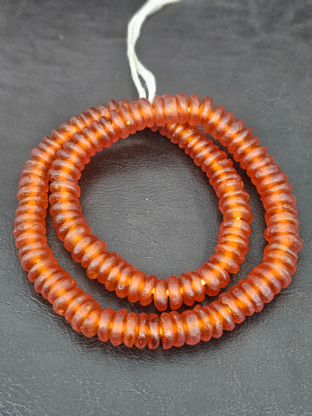 Authentic handmade amber copper Krobo translucent recycled glass rondelle beads from Ghana featuring a matte frosted finish for jewelry making, designer collections, and wholesale sourcing.