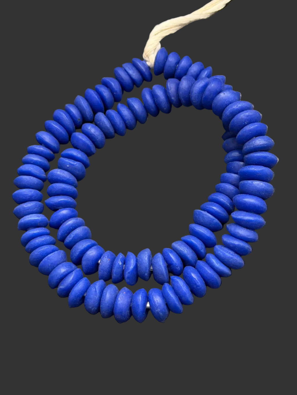 Handcrafted royal blue Ashanti glass rondelle beads from Ghana made from recycled glass featuring large holes and a smooth matte artisan finish.