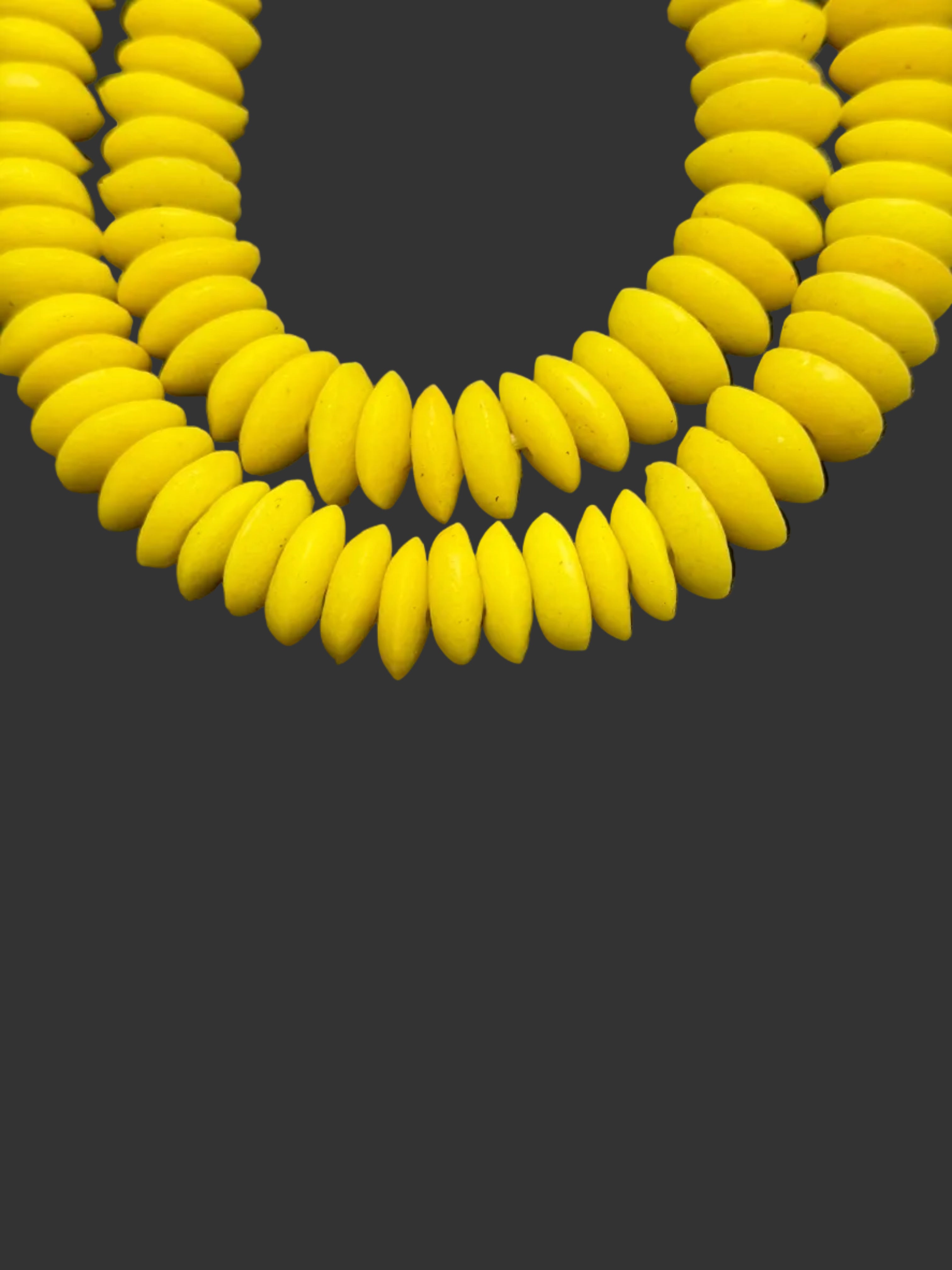 Close up image of handcrafted Sankofa Gold Ashanti glass rondelle beads from Ghana made from recycled glass featuring large holes and a vibrant matte artisan finish.