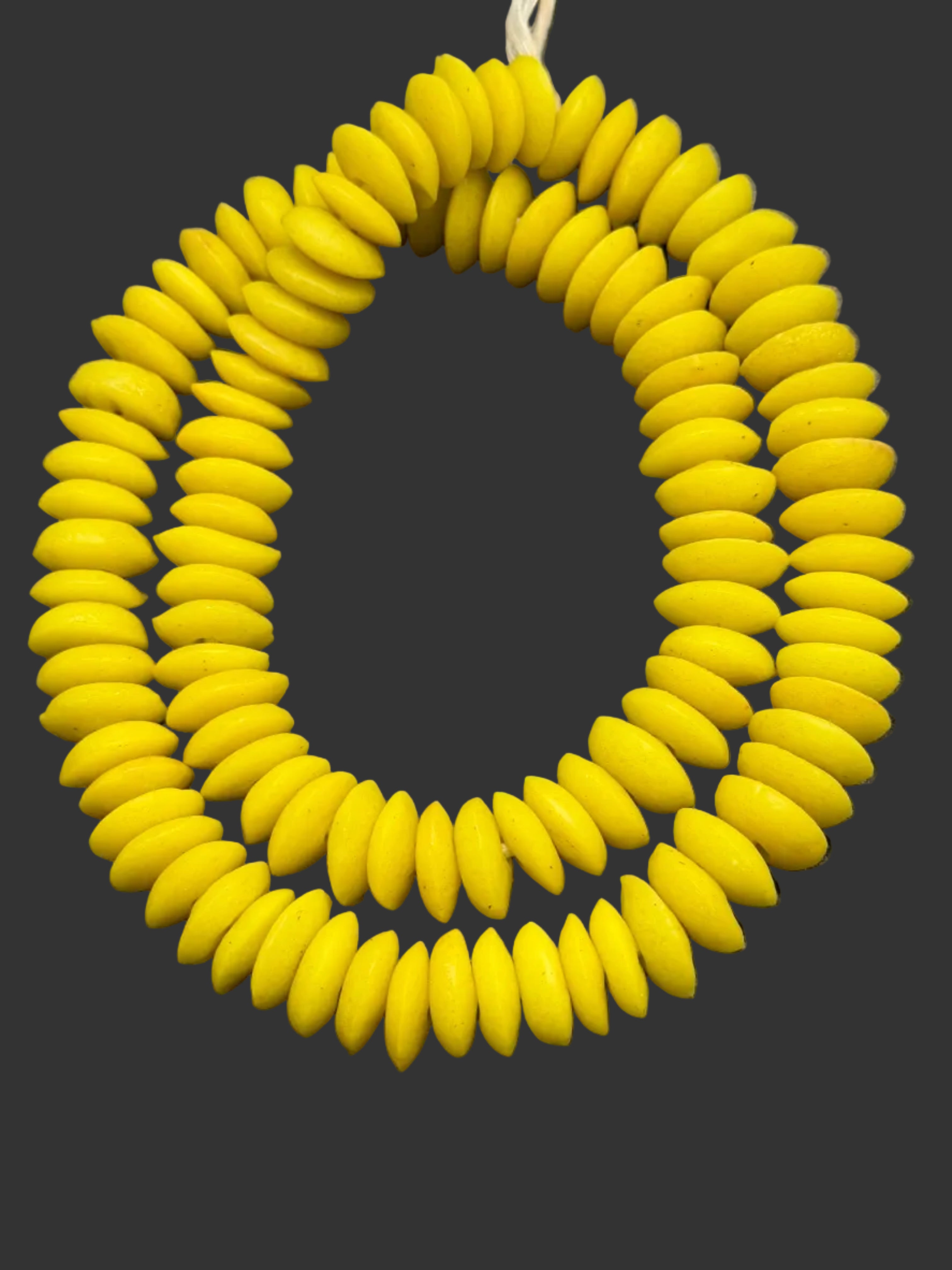 Handcrafted Sankofa Gold Ashanti glass rondelle beads from Ghana made from recycled glass featuring large holes and a vibrant matte artisan finish.