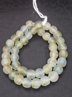 Authentic African beads from Ghana featuring chunky translucent recycled glass Krobo beads in ocean mist blue, seafoam green, and warm sand tones with a frosted artisan finish for sustainable jewelry making and luxury design.