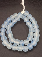 Authentic African beads from Ghana featuring chunky ice blue translucent recycled glass Krobo beads handcrafted by artisans with a matte frosted finish for sustainable jewelry making.