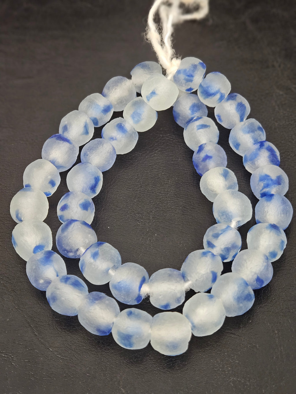 Authentic African cobalt blue translucent Krobo recycled glass beads handcrafted in Ghana featuring frosted round handmade beads created from recycled glass for luxury jewelry making.