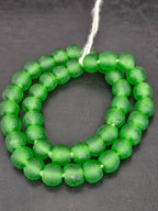 Authentic African translucent green Krobo recycled glass beads handcrafted in Ghana featuring frosted handmade round beads created from recycled glass for luxury jewelry making.