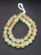 Authentic African honey gold translucent Krobo recycled glass beads handcrafted in Ghana featuring chunky matte frosted round beads made from recycled glass for sustainable jewelry making.