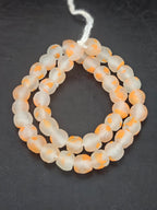Authentic African orange speckled translucent Krobo recycled glass beads handcrafted in Ghana featuring frosted handmade round beads created from recycled glass for luxury jewelry making.