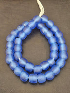 Authentic African cobalt blue translucent Krobo recycled glass beads handcrafted in Ghana featuring frosted handmade round beads for luxury jewelry making and designer collections.