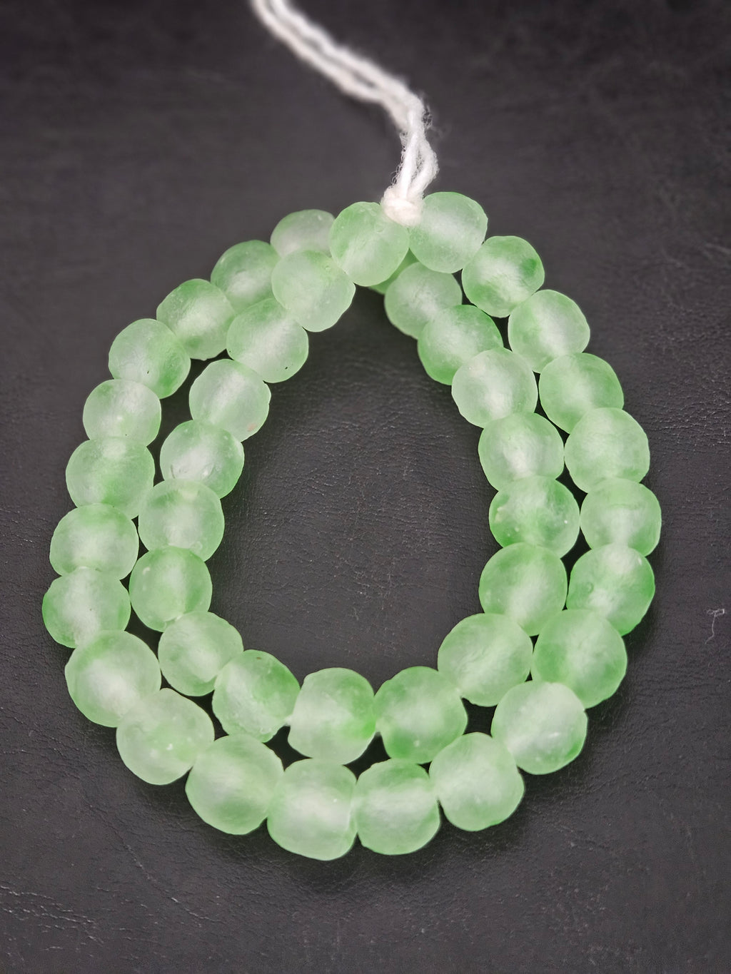 Authentic mint green translucent Krobo recycled glass beads handcrafted in Ghana featuring frosted handmade round beads for luxury jewelry making, sustainable designer collections, and contemporary artisan creations.
