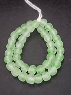 Authentic mint green translucent Krobo recycled glass beads handcrafted in Ghana featuring frosted handmade round beads for luxury jewelry making, sustainable designer collections, and contemporary artisan creations.