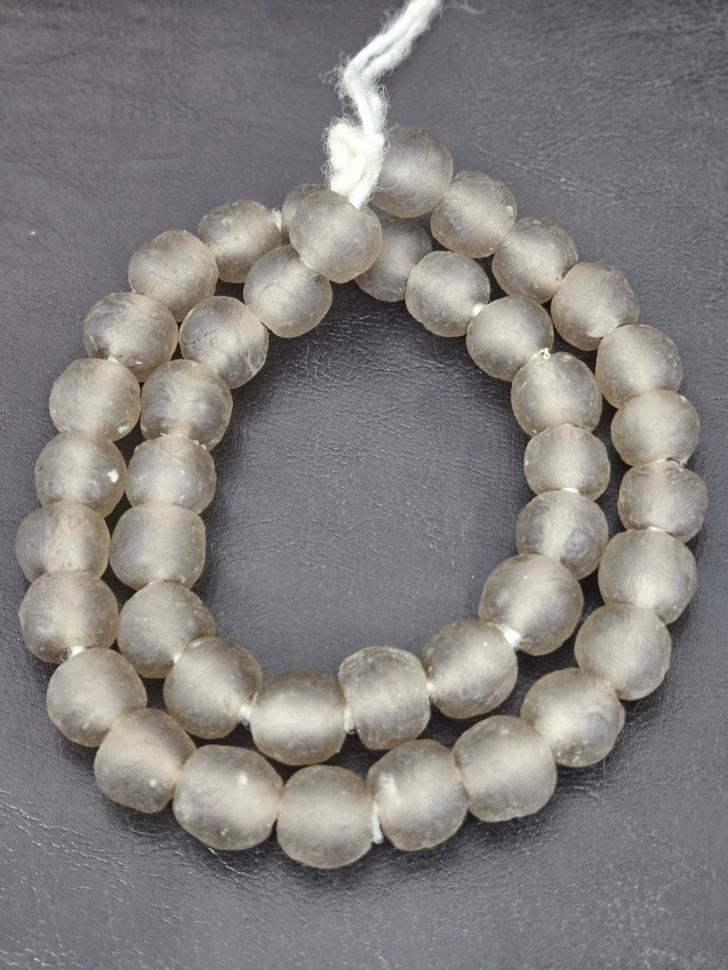 Authentic smoke gray translucent Krobo recycled glass beads handcrafted in Ghana featuring frosted handmade round beads for luxury jewelry making, sustainable designer collections, and contemporary artisan creations