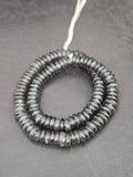 Authentic handmade black Krobo translucent recycled glass rondelle beads from Ghana with matte frosted finish arranged as a full strand for jewelry making and wholesale design.