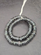 Authentic handmade black Krobo translucent recycled glass rondelle beads from Ghana with matte frosted finish arranged as a full strand for jewelry making and wholesale design.