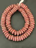 Authentic handcrafted Coral Fused Krobo Rondelle Recycled Glass Beads from Ghana featuring intricate ivory and black artisan patterns arranged as a full strand for jewelry designers, collectors, and sustainable luxury jewelry making.