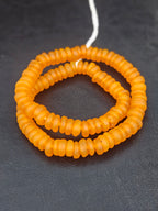 Authentic golden amber Krobo translucent recycled glass rondelle beads handcrafted in Ghana featuring matte frosted handmade disc beads for luxury jewelry making, sustainable designer collections, and artisan creations.