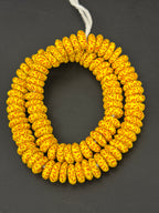 Authentic handcrafted golden yellow Fused Krobo Rondelle Recycled Glass Beads from Ghana featuring terracotta artisan patterns and matte recycled glass finish displayed as a full designer strand for jewelry making and wholesale sourcing.