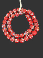 Handcrafted crimson red fused Krobo recycled glass beads from Ghana featuring artisan marbled patterns in ivory navy blue and charcoal accents.