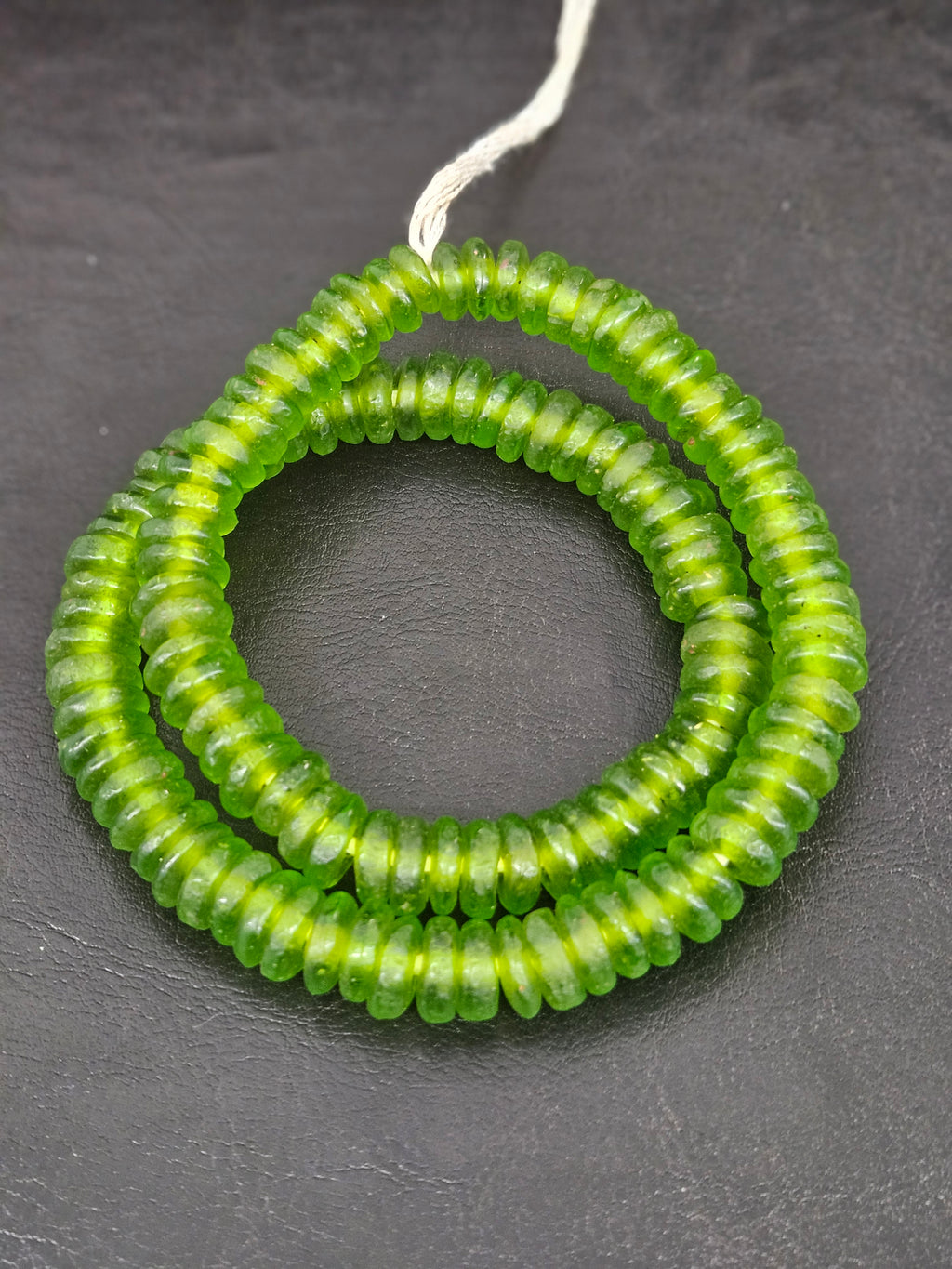 Authentic handmade lime green Krobo translucent recycled glass rondelle beads from Ghana featuring a frosted matte finish for jewelry making and wholesale sourcing.