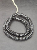 Authentic handmade matte black Krobo translucent recycled glass rondelle beads from Ghana featuring a soft matte finish for jewelry making, designer collections, and wholesale sourcing.