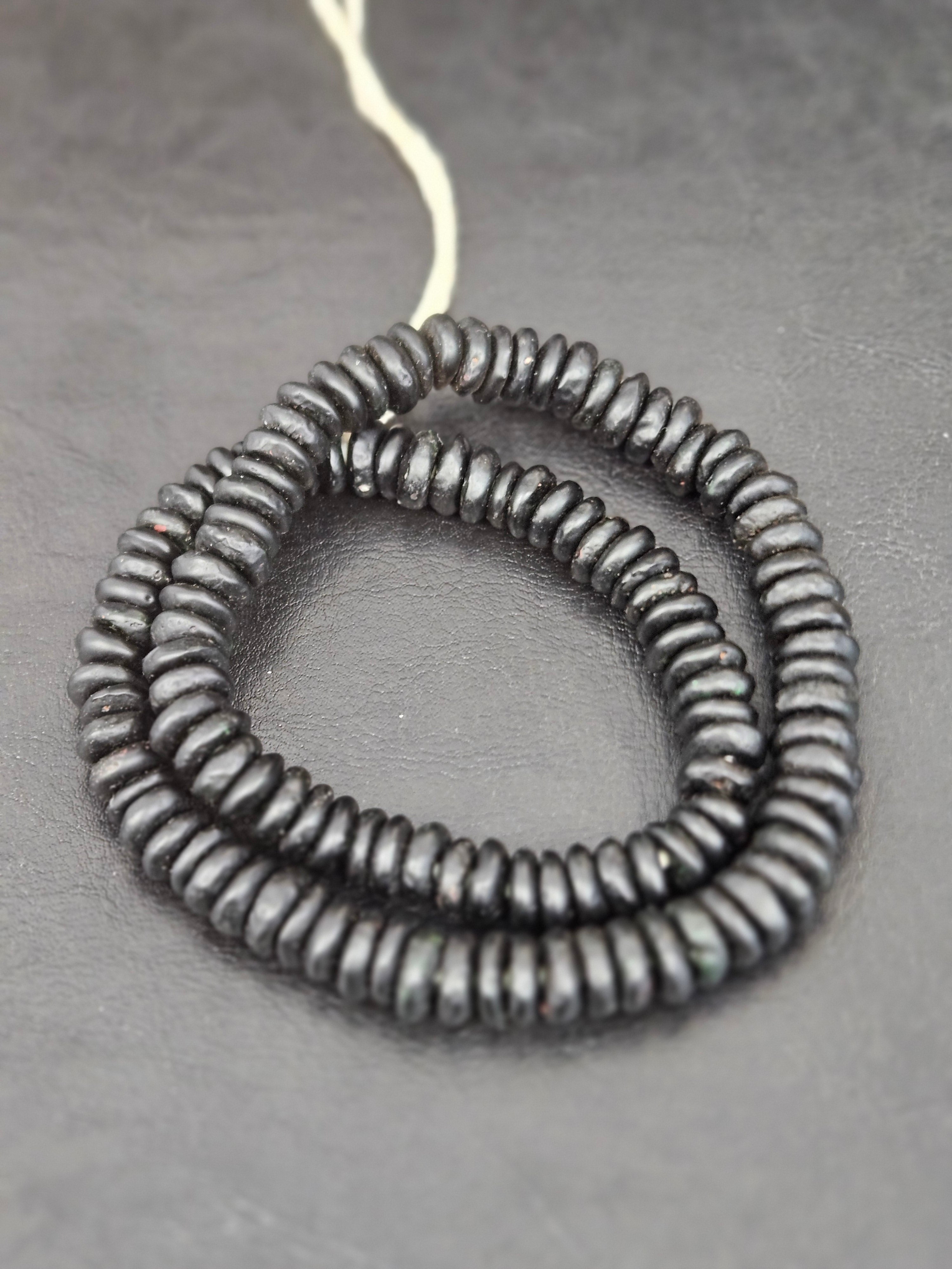 Authentic handmade matte black Krobo translucent recycled glass rondelle beads from Ghana featuring a soft matte finish for jewelry making, designer collections, and wholesale sourcing.