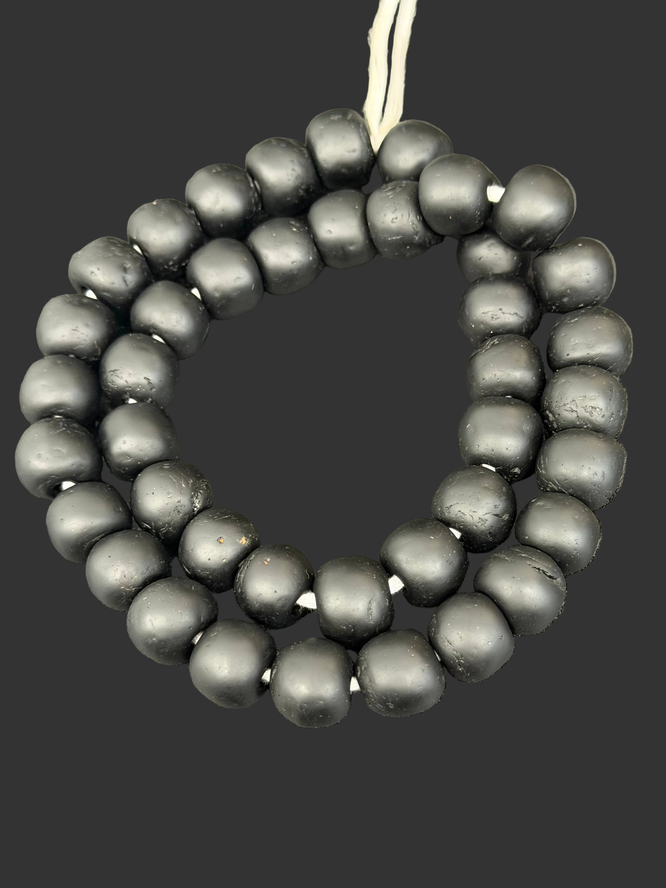 Handcrafted Midnight Eclipse Krobo Pocket Glass Beads from Ghana featuring matte black recycled glass with authentic artisan craftsmanship.