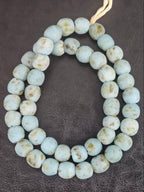Authentic handcrafted mist blue Krobo powdered glass beads from Ghana featuring organic round recycled glass beads with matte finish and natural ivory earth speckles on strand.