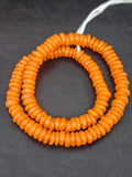 Authentic handmade orange Krobo translucent recycled glass rondelle beads from Ghana featuring a vibrant matte finish for jewelry making, designer collections, and wholesale sourcing.