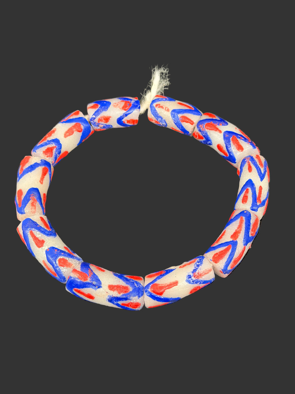Handcrafted red white and blue painted Krobo glass beads from Ghana featuring large-hole tube beads made from recycled glass for statement jewelry and heritage-inspired designs.