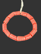 Handcrafted red and white painted Krobo glass beads from Ghana featuring detailed white polka dot patterns on large-hole recycled glass tube beads.