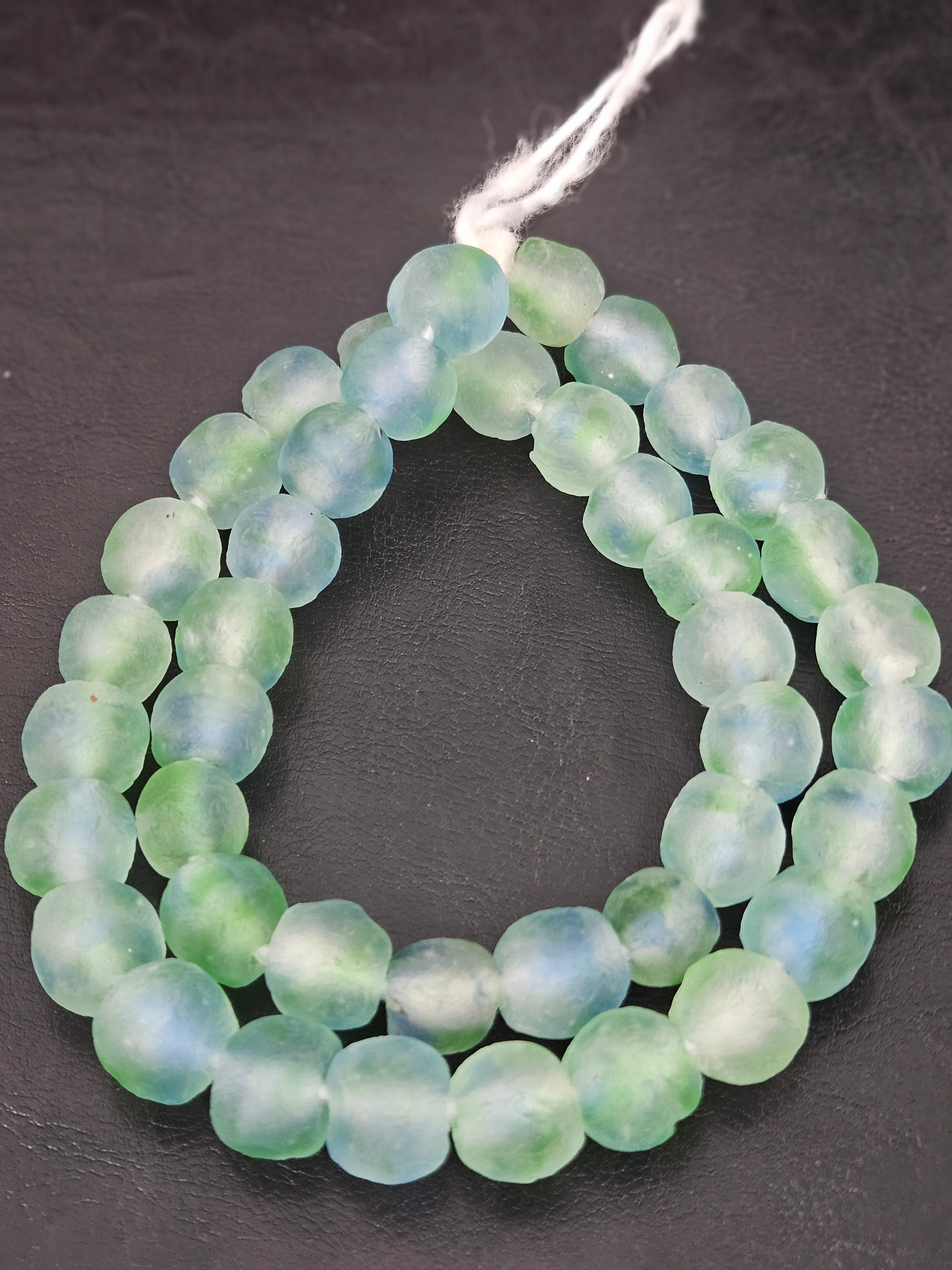 Authentic seafoam blue and mint Krobo translucent recycled glass beads handcrafted in Ghana featuring frosted handmade round beads for luxury jewelry making, sustainable designer collections, and artisan creations.