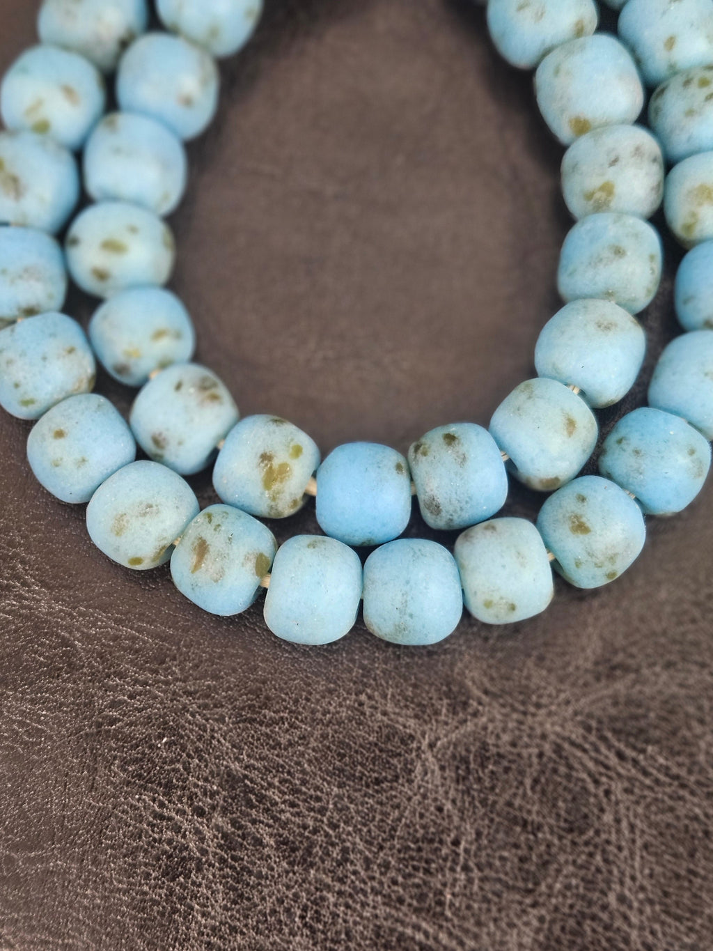 Authentic handcrafted sky blue Krobo powdered glass beads from Ghana featuring organic round recycled glass beads with matte finish and natural earth-toned artisan speckles.