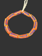 Handcrafted orange blue and white painted Krobo glass beads from Ghana featuring traditional geometric patterns on recycled glass tube beads.