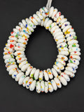 Authentic handcrafted White Fused Krobo Rondelle Recycled Glass Beads from Ghana featuring colorful recycled glass confetti accents arranged on a strand for jewelry designers, collectors, and sustainable artisan projects.