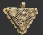 Close-up of Ghanaian brass Sankofa pendant showing the raised bird motif, lattice framework, and concentric spiral details.
