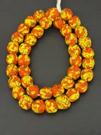 Handcrafted Fused Krobo recycled glass beads from Ghana featuring vibrant yellow and orange marbled patterns on approximately 44 artisan-made beads