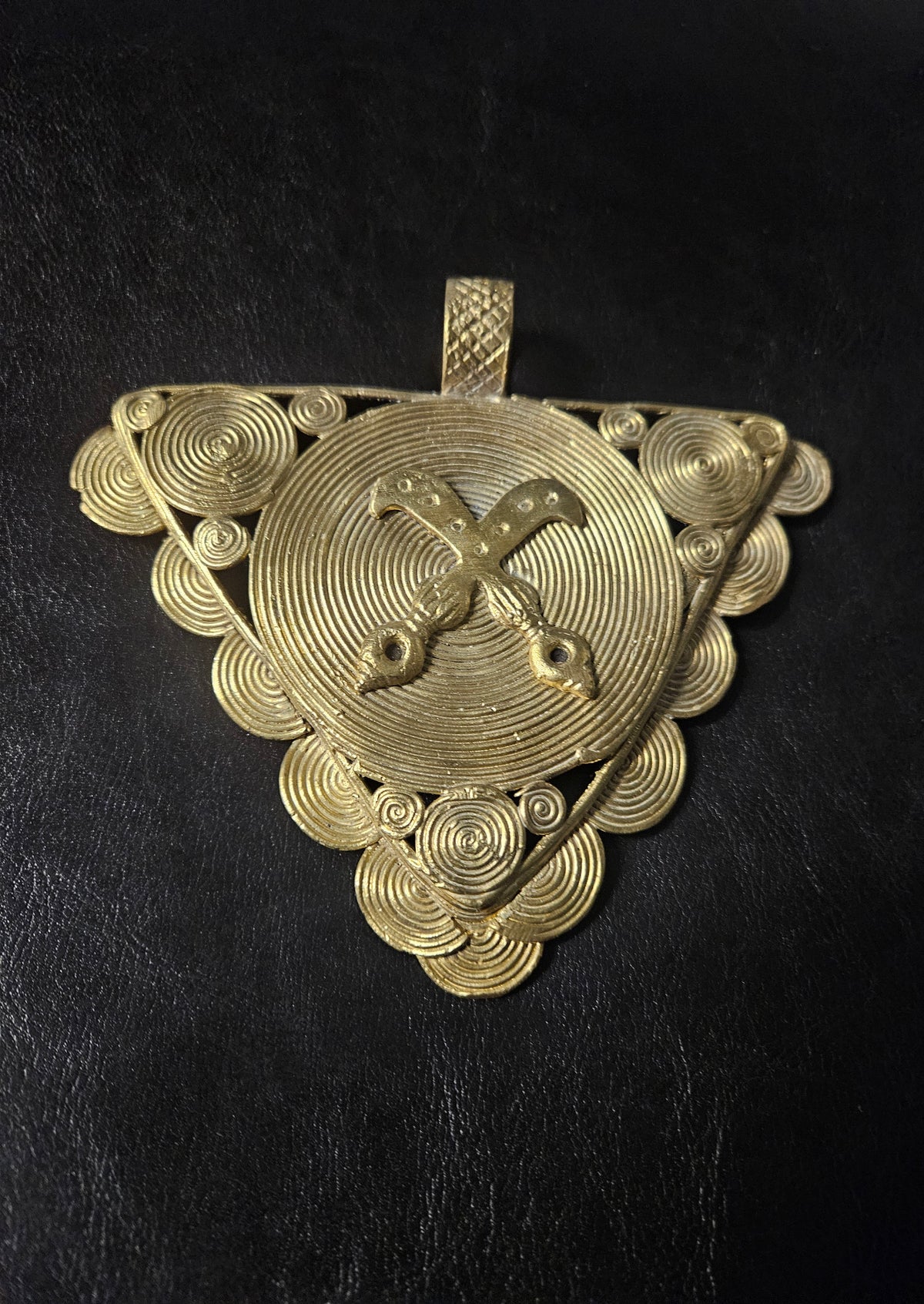 Oversized Akofena Adinkra brass pendant from Ghana with crossed swords on a concentric circular center.