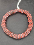 Handcrafted brown and coral red Krobo glass spacer beads from Ghana featuring recycled glass artisan craftsmanship and striped spacer-bead design.
