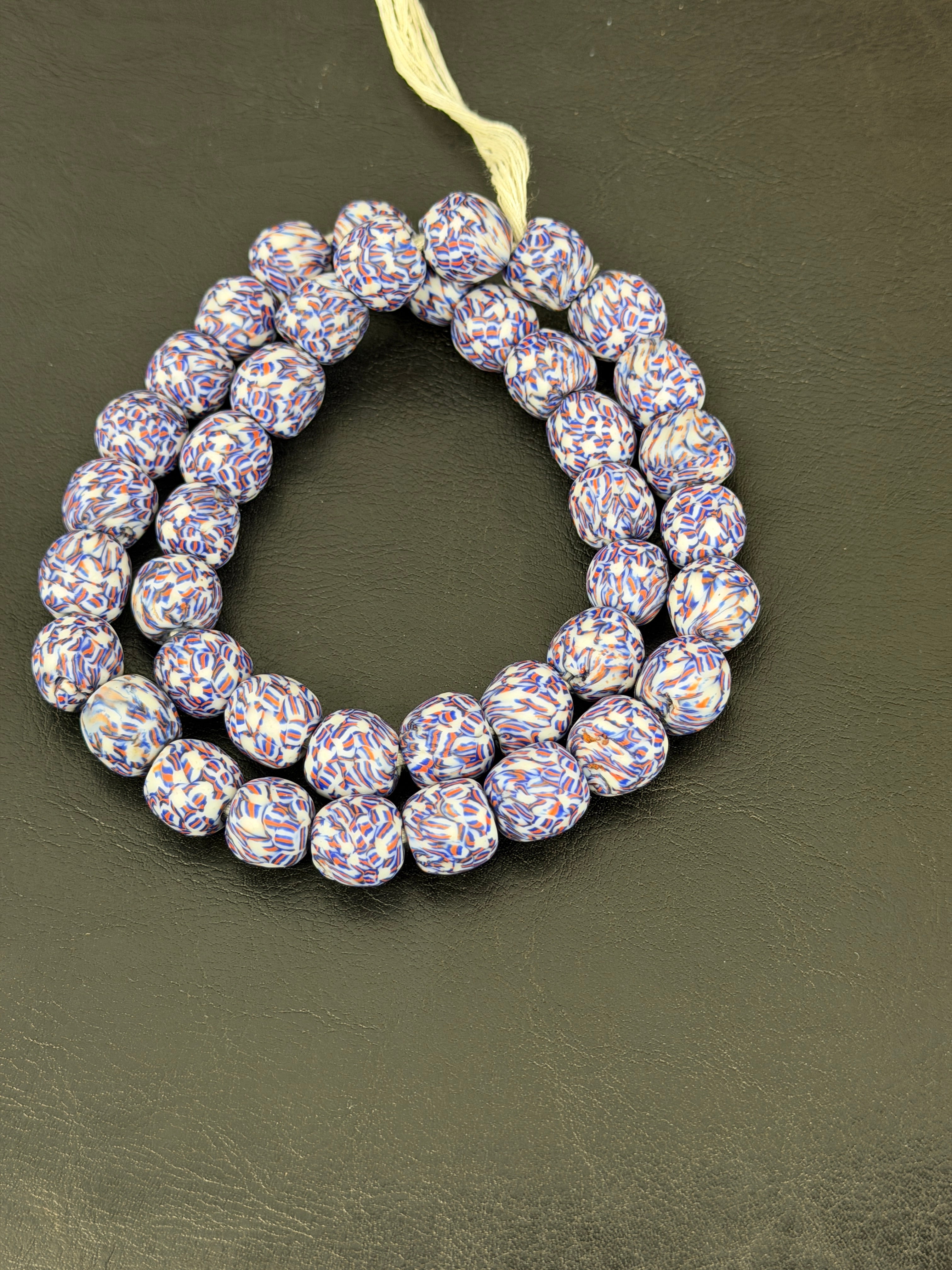 Authentic confetti mosaic Fused Krobo recycled glass beads handcrafted in Ghana featuring ivory white, indigo blue and terracotta artisan patterning.