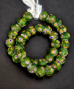 Strand of emerald green African trade beads sourced in Ghana featuring blue, white, yellow, and red eye motifs, approximately 15–16mm with large 7–8mm holes for jewelry making, collecting, and decorative arts.