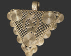 Front view of oversized Gye Nyame Adinkra brass pendant from Ghana with triangular openwork design, spiral decoration, and large bail.
