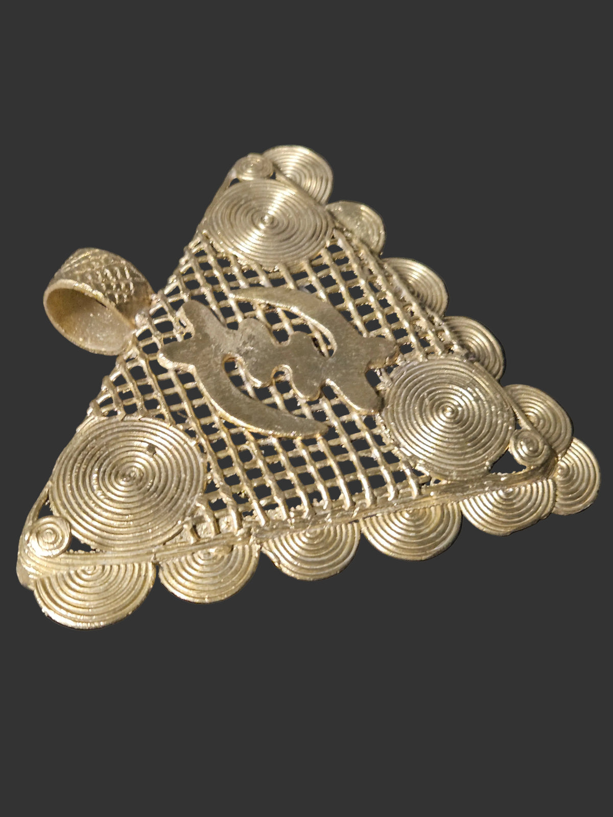 Detail of the large textured brass bail on a handcrafted Gye Nyame pendant from Ghana.
