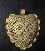 Oversized Akofena Adinkra brass pendant from Ghana with raised crossed-sword motif, layered openwork, spiral border, and textured top bail.