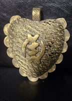 Oversized Gye Nyame Adinkra brass pendant from Ghana with central symbol, layered linear detailing, spiral border elements, and large bail.