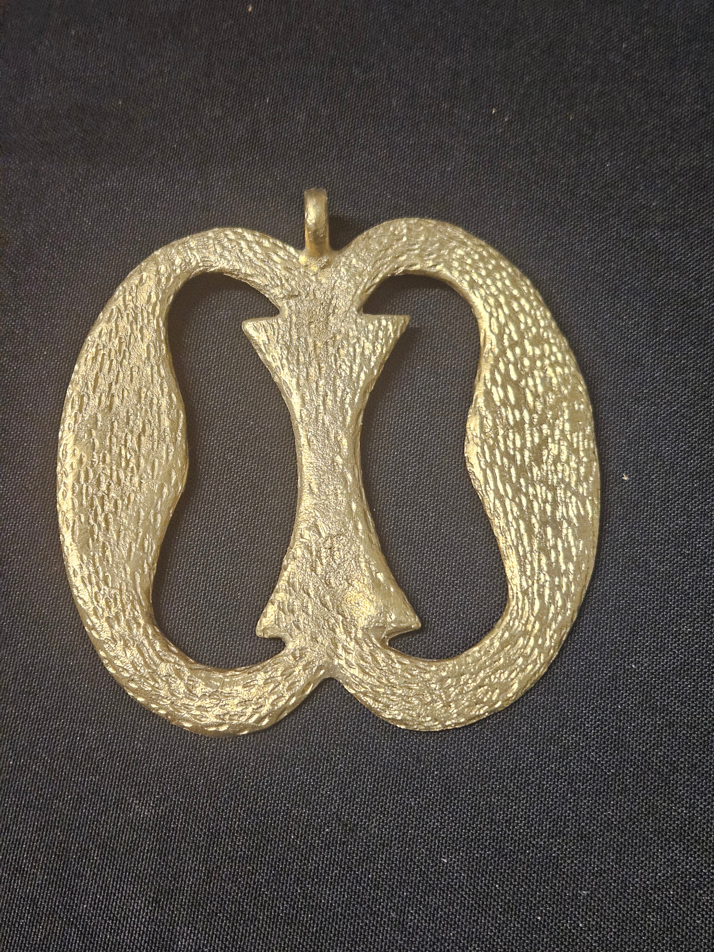 Oversized handcrafted Nkonsonkonson Adinkra symbol pendant made from traditional Ashanti brass in Ghana representing unity, interconnectedness, cooperation, and human relationships.