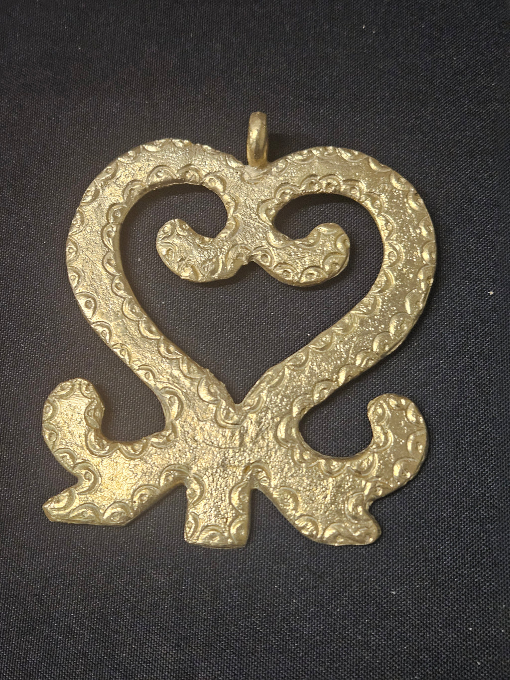 Oversized handcrafted Sankofa Adinkra symbol pendant made from traditional Ashanti brass in Ghana representing learning from the past, cultural heritage, wisdom, and continuity.