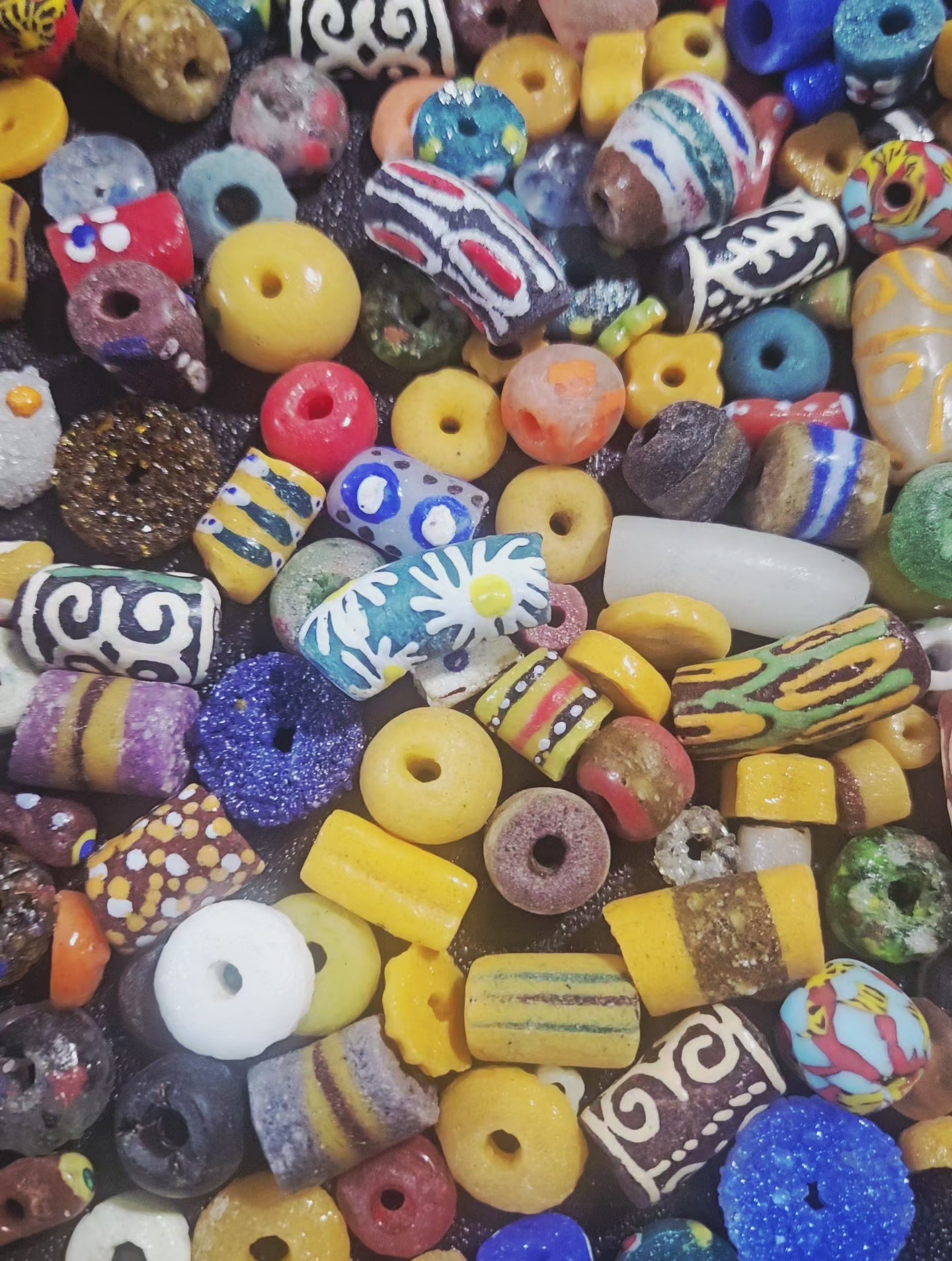 Video close-up highlighting jewel-tone Krobo beads shimmering under light.