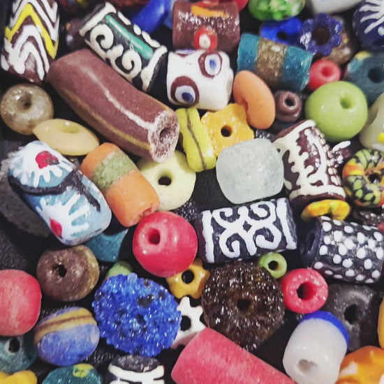 Video close-up of speckled Krobo beads under natural light.