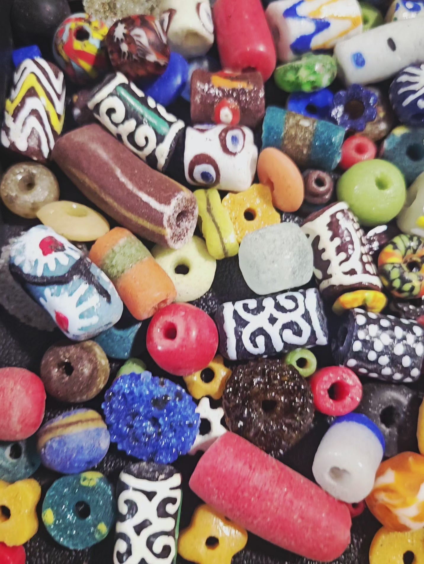 Video close-up of speckled Krobo beads under natural light.