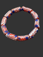 Handcrafted red white and blue painted Krobo glass beads from Ghana featuring blue dot accents and traditional artisan patterns on recycled glass tube beads.
