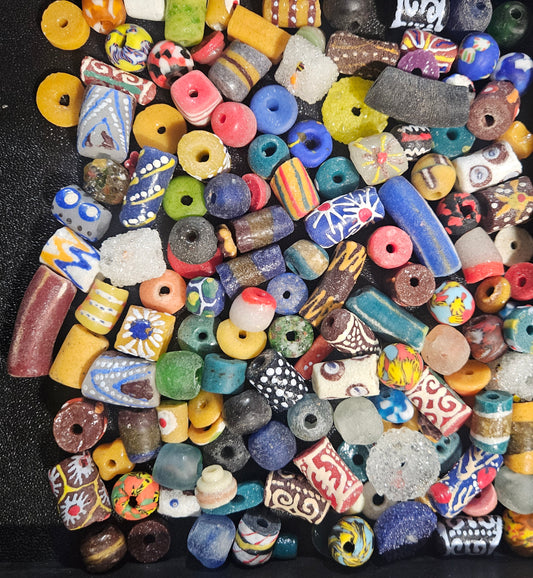 Close-up of layered assorted Krobo artisan beads showing mixed sizes and colors.
